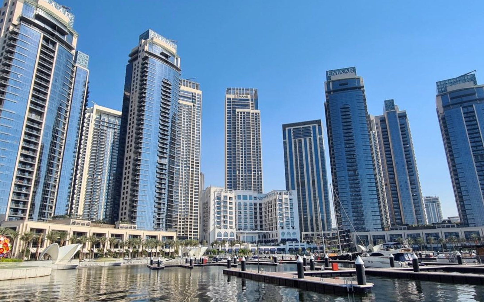 Emaar residential towers rising above the marina at Dubai Creek Harbour, with yachts moored at the pontoons, photographed by Stefano Iannotti